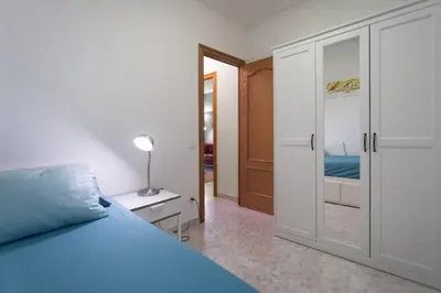 a bedroom with a blue bed and a closet at Apartment in front of the Beach in Pineda de Mar