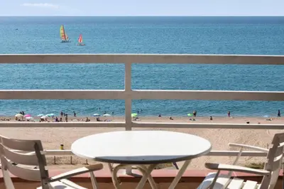 a table and chairs on a balcony with the beach at Apartment in front of the Beach in Pineda de Mar