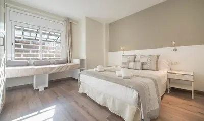 a white bedroom with a bed and a window at You Stylish El Born Apartments in Barcelona