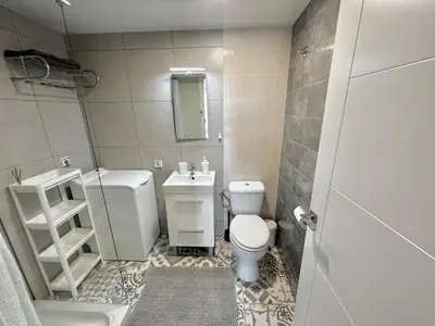 a bathroom with a toilet and a sink and a mirror at Amazing Badalona Apartment With Terrace in Badalona