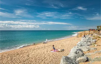 a group of people sitting on the beach at Gorgeous Apartment In Pineda De Mar in Pineda de Mar