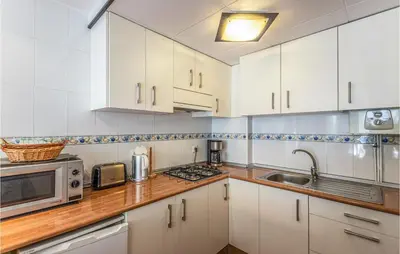 a kitchen with white cabinets and a sink and a microwave at Gorgeous Apartment In Pineda De Mar in Pineda de Mar