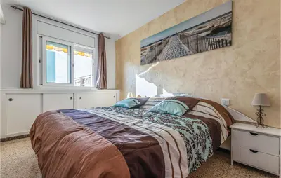 a bedroom with a bed and a large window at Gorgeous Apartment In Pineda De Mar in Pineda de Mar