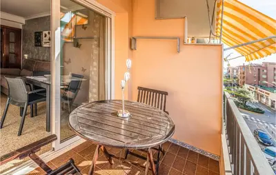 a wooden table on a balcony with a table at Gorgeous Apartment In Pineda De Mar in Pineda de Mar
