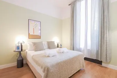a bedroom with a bed with white sheets and a window at Sweett - Sepulveda in Barcelona
