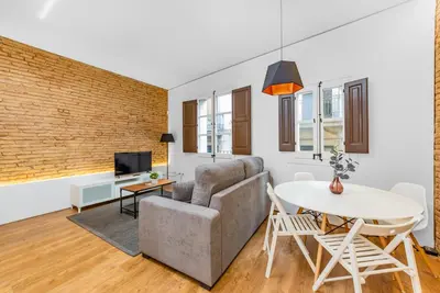 a living room with a couch and a table at Sant Pau Ramblas Apartments Serennia in Barcelona