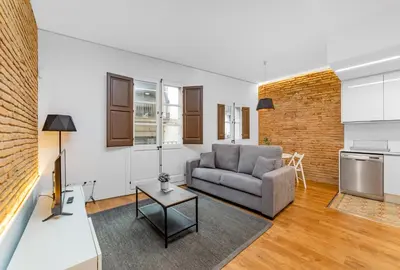 a living room with a couch and a table at Sant Pau Ramblas Apartments Serennia in Barcelona