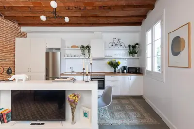 a kitchen with white cabinets and a counter top at Casa Cosi - Putxet 4 in Barcelona