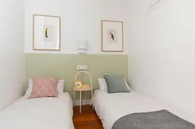 two twin beds in a room with white walls at Casa Cosi - Putxet 4 in Barcelona