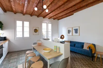 a living room with a blue couch and a table at Casa Cosi - Putxet 4 in Barcelona