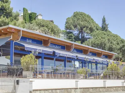 a building with blue trim with a mountain in the background at Villa in Arenys de Mar with Sea View in Arenys de Mar