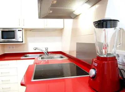 a red blender on a red counter in a kitchen at Panier en Osier · Panier en Osier · Charming apartment w/private terrace 2min from sea in Vilassar de Mar