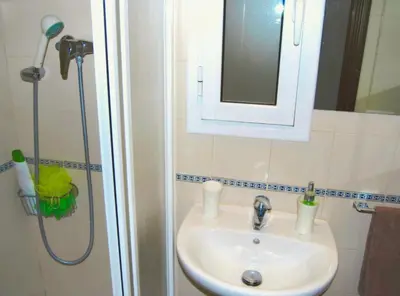 a bathroom with a sink and a shower with a mirror at Panier en Osier · Panier en Osier · Charming apartment w/private terrace 2min from sea in Vilassar de Mar