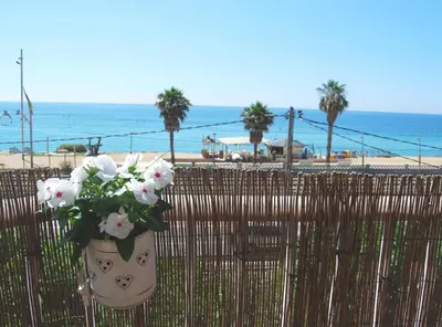 a vase of flowers on a fence near the beach at Panier en Osier · Panier en Osier · Charming apartment w/private terrace 2min from sea in Vilassar de Mar