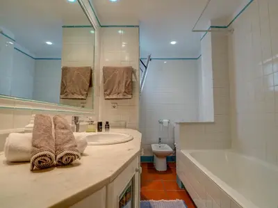 a bathroom with a sink and a tub and a toilet at Montroig Zen Penthouse by Hello Homes Sitges in Sitges