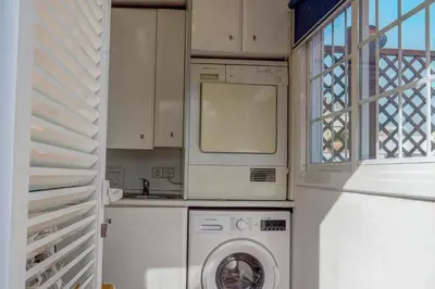 a washer and dryer in a kitchen with a window at Montroig Zen Penthouse by Hello Homes Sitges in Sitges