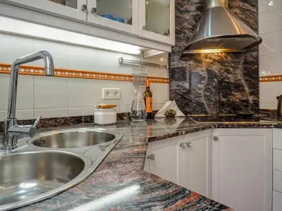 a kitchen with a sink and a counter top at Montroig Zen Penthouse by Hello Homes Sitges in Sitges