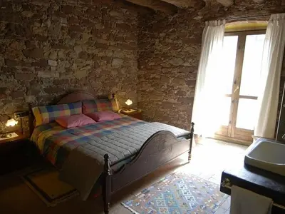 a bedroom with a bed and a brick wall at El Folló Turisme Rural in Tagamanent