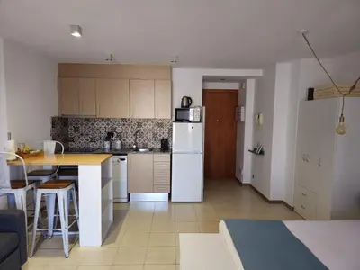 a kitchen with a white refrigerator and a table at Mataró Center Apartment in Mataró