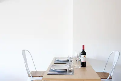 a wooden table with a bottle of wine and glasses at Mataró Center Apartment in Mataró