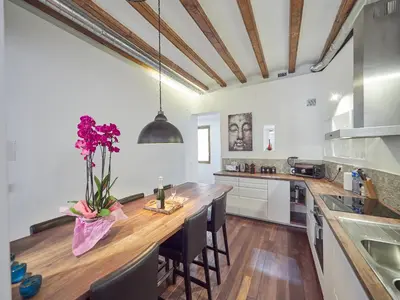 a kitchen with a large wooden counter with purple flowers on it at BarcelonaForRent Alessandra Ramblas in Barcelona