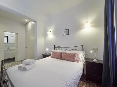 a bedroom with a white bed with two towels on it at BarcelonaForRent Alessandra Ramblas in Barcelona