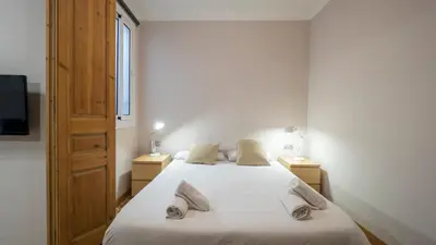 a bedroom with two beds and two lamps and a television at Acogedor apartamento de 2 dormitorios in Barcelona
