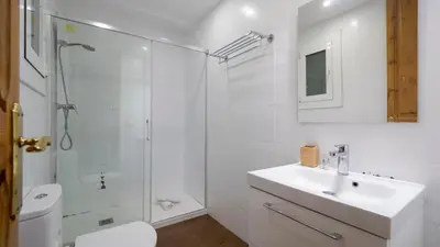 a white bathroom with a sink and a shower at Acogedor apartamento de 2 dormitorios in Barcelona