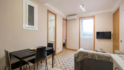 a room with a dining table and a bedroom at Acogedor apartamento de 2 dormitorios in Barcelona