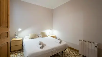 a bedroom with a white bed with two pillows on it at Acogedor apartamento de 2 dormitorios in Barcelona