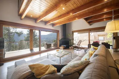 a living room with a couch and large windows at Catalunya Casas Infinity pool and views 20min to Barcelona in Torrelles de Llobregat
