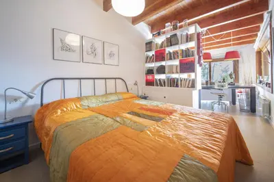 a bedroom with a large bed with an orange blanket at Catalunya Casas Infinity pool and views 20min to Barcelona in Torrelles de Llobregat