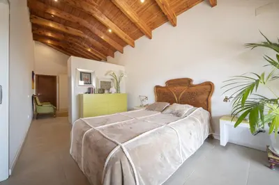 a bedroom with a large bed and a wooden ceiling at Catalunya Casas Infinity pool and views 20min to Barcelona in Torrelles de Llobregat