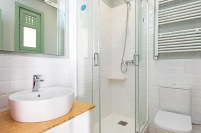 a bathroom with a sink and a glass shower at Modernist Family Apartment by PriorityVillas in Barcelona
