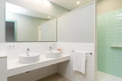 a bathroom with two sinks and a large mirror at Modernist Family Apartment by PriorityVillas in Barcelona