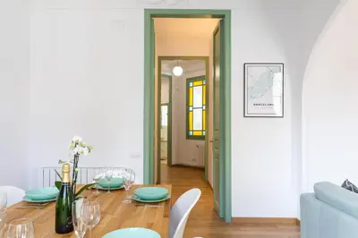 a living room with a table and a blue couch at Modernist Family Apartment by PriorityVillas in Barcelona