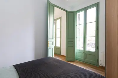 a bedroom with green doors and a bed in it at Modernist Family Apartment by PriorityVillas in Barcelona