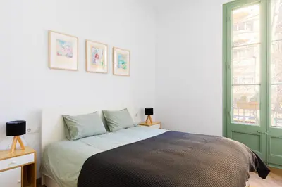 a bedroom with a bed and a green door at Modernist Family Apartment by PriorityVillas in Barcelona