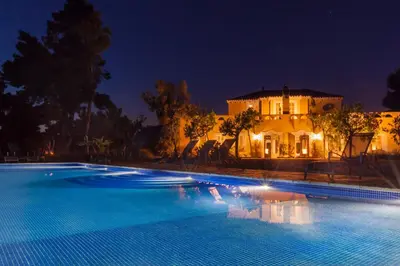 a large swimming pool in front of a house at night at Casa Nova Estate in Sitges
