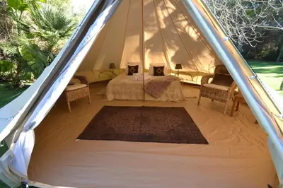 a tent with two beds and chairs in it at Casa Nova Estate in Sitges