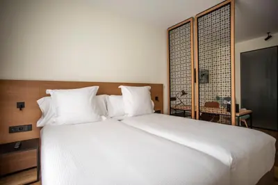 a large white bed with white pillows in a bedroom at Hotel Paxton Barcelona in Barcelona