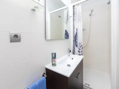 a white bathroom with a sink and a mirror at Apartment Gracia- Providencia by Interhome in Barcelona