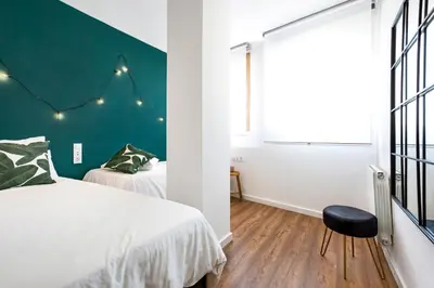 a bedroom with a bed and a green wall at Glam Penthouse Barcelona in Barcelona