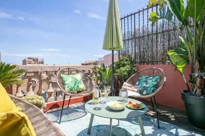 a patio with a table and chairs on a balcony at Glam Penthouse Barcelona in Barcelona