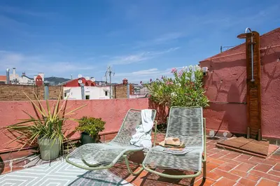 two chairs sitting on a patio on a roof at Glam Penthouse Barcelona in Barcelona