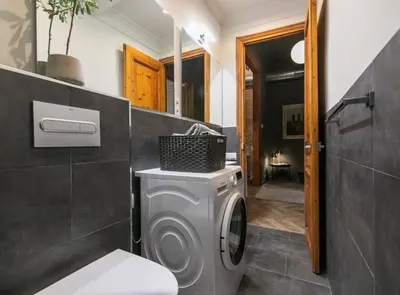 a bathroom with a washing machine and a sink at Avinyo 2 Gotic · Spacious Loft in Gothic Quarter! in Barcelona
