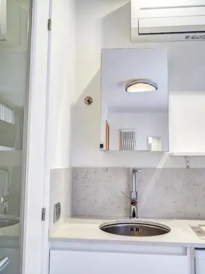 a kitchen counter with a sink and a mirror at Blue Serenity by Hello Homes Sitges in Sitges