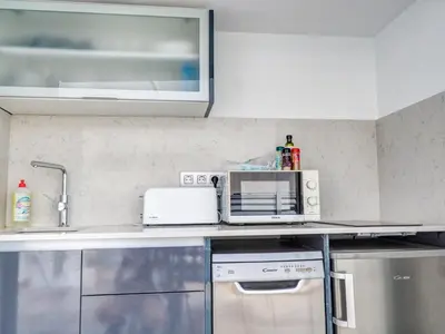 a kitchen counter with a microwave and a sink at Blue Serenity by Hello Homes Sitges in Sitges