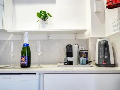 a bottle of wine sitting on a counter with two glasses at Blue Serenity by Hello Homes Sitges in Sitges