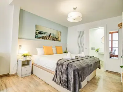 a bedroom with a large white bed with orange pillows at The Green Oasis by Hello Homes Sitges in Sitges
